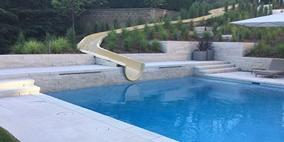 Custom Built Pool With Water Slide Built Into The Landscaping.
