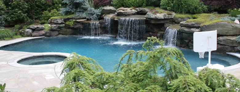 Custom Shaped Swimming Pool Fed By Waterfalls & a Built-In Spa
